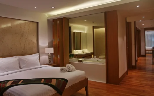 Гостевая спальня с большой кроватью и деревянным полом открытая зона ванной