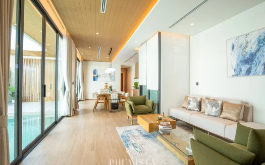 Светлая гостиная с деревянным потолком, бежевым диваном и зелеными креслами