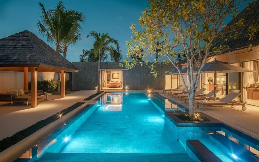 Зона бассейна ночью с голубой подсветкой воды и пальмами