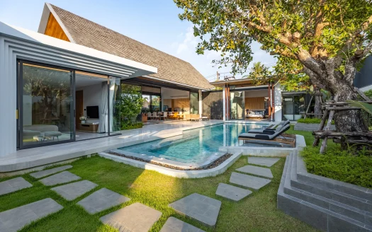 Наружный бассейн с шезлонгами у стеклянной виллы