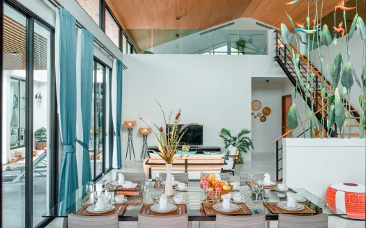 Яркая гостиная и столовая с стеклянным столом и растениями