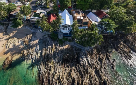 Воздушный вид на дом на утесе с пальмами и бирюзовым морем