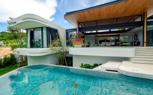 Современная вилла с изогнутым балконом и стеклянной перилой у бассейна