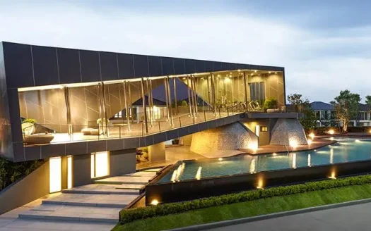 Сумеречный экстерьер современного стеклянного дома с подсвеченным бассейном