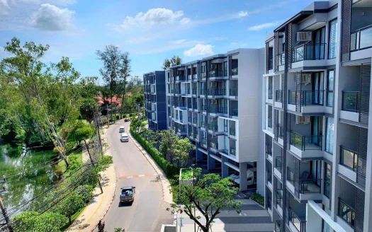 Современный фасад жилого комплекса вдоль улицы с балконами