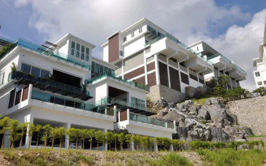 Современный белый жилой комплекс на скалистом холме с стеклянными балконами