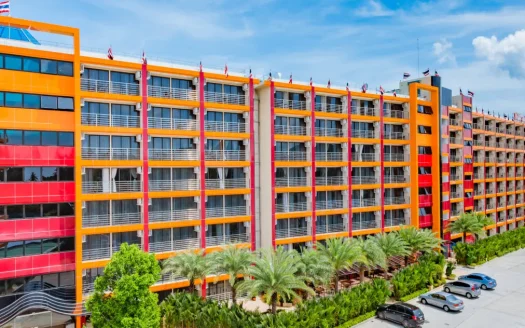 Экстерьер ярко-оранжевого и красного фасада отеля с балконами