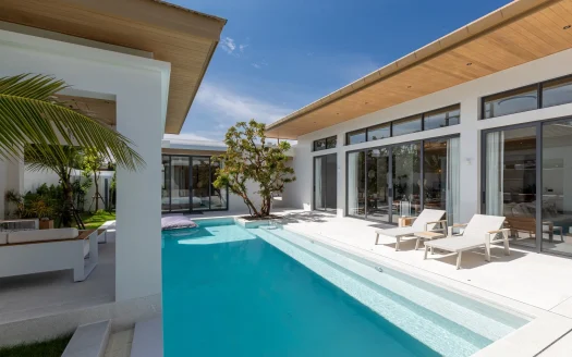 Современный дом с прямоугольным бассейном и шезлонгами