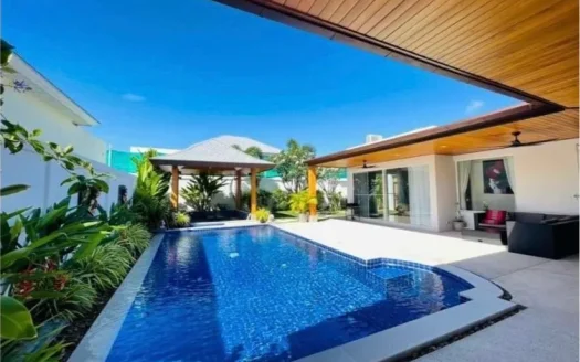 Уличный бассейн с синими плитками возле современной террасы виллы