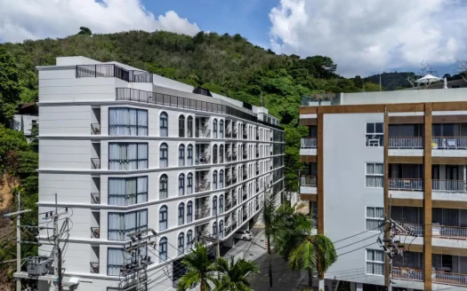 Белый жилой дом с арочными окнами на холме под голубым небом