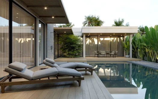 Современная территория с прямоугольным бассейном, стеклянными стенами и лежаками