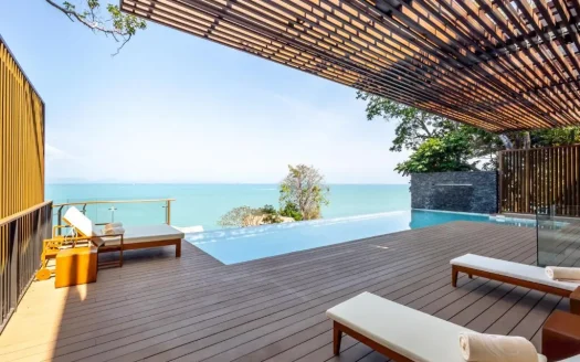 Терраса у бассейна с деревянной отделкой и шезлонгами у моря