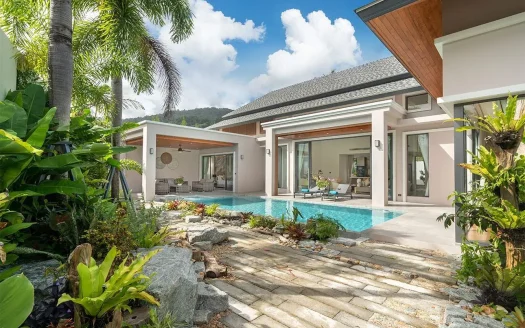 Уличный двор виллы с прямоугольным бассейном, зоной отдыха и тропическими растениями
