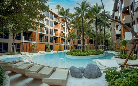 Изогнутый курортный бассейн, окружён пальмами и современными зданиями