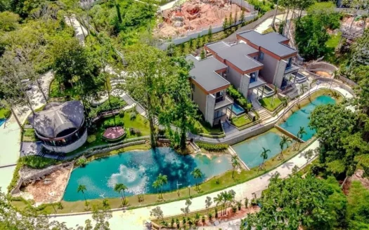 Аэросъемка современных вилл вдоль изогнутого бирюзового бассейна