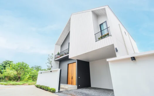 Белый современный дом с угловатым фасадом и балконными ящиками