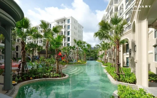 Уличный курортный бассейн во внутреннем дворе с пальмами и бежевыми зданиями