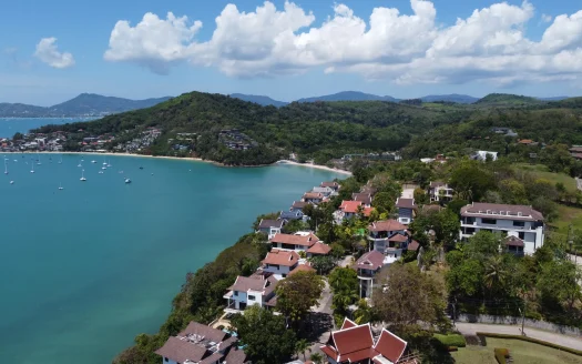 Воздушный вид бирюзовой бухты с яхтами и домами на холмах