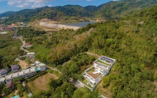 Аэроизображение виллы на холме с белым фасадом и бассейном